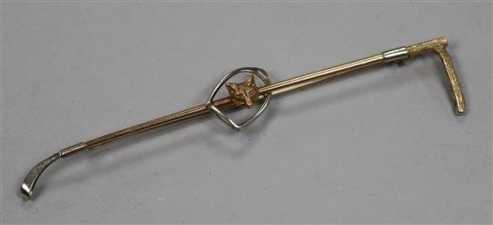 An early 20th century yellow metal riding crop, spur and fox head bar brooch, 89mm.